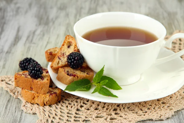 Filiżanka herbaty z plików cookie a blackberry na stół szczegół — Zdjęcie stockowe