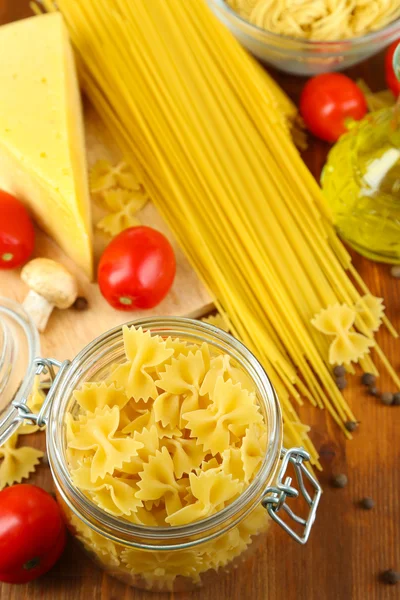 Nudeln mit Öl, Käse und Gemüse auf Holztisch in Großaufnahme — Stockfoto