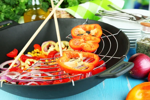 Verdure in wok su tavolo di legno su sfondo naturale — Foto Stock