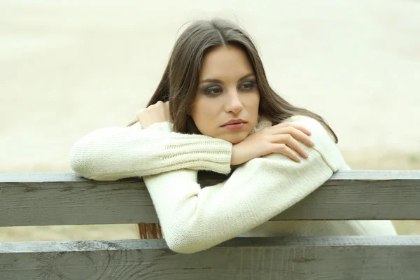 Jovem mulher solitária no banco no parque — Fotografia de Stock