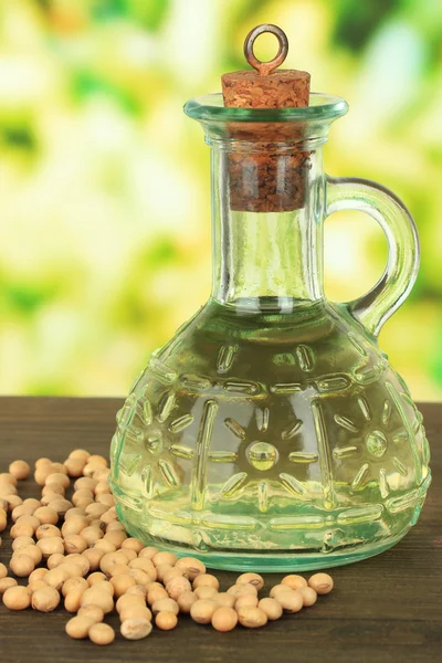 Soy beans and oil on table on bright background — Stock Photo, Image