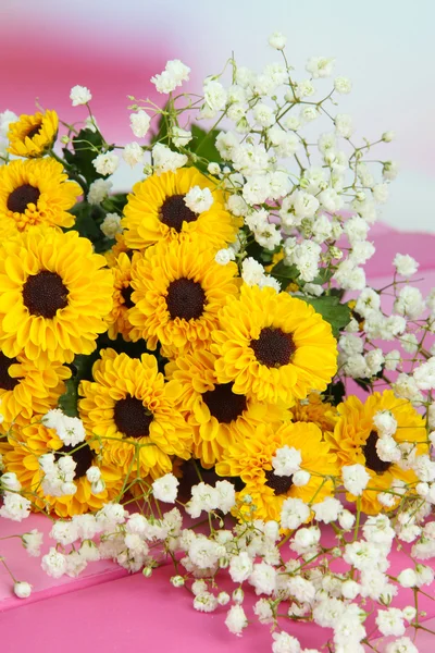 Piękne kwiaty na stole na jasnym tle — Zdjęcie stockowe