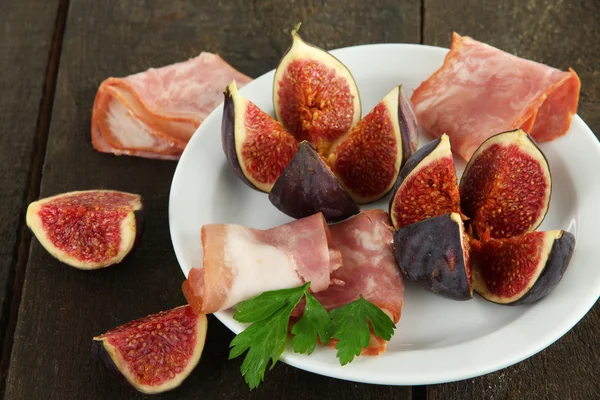 Fichi saporiti con prosciutto sul tavolo di legno grigio — Foto Stock