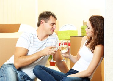 Young couple celebrating moving to new home clipart