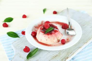Panna cotta ahşap zemin üzerinde frambuaz sos ile