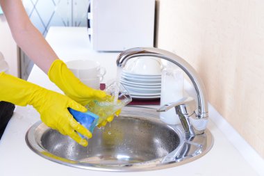 Mutfakta bulaşık yıkayan kadınların ellerini kapat.