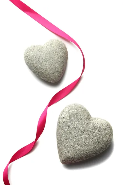Piedras grises en forma de corazón y cinta de color, aisladas en blanco — Foto de Stock