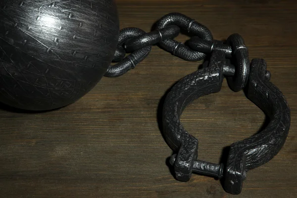 Ball and chain on wooden background — Stock Photo, Image