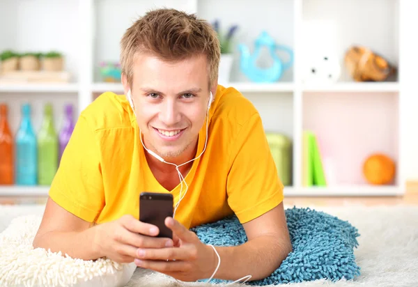 Young man relaxing carpet and listening to music — Stock Photo, Image