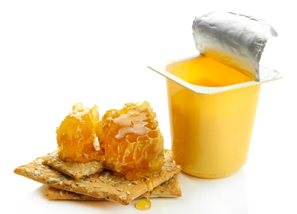 Sobremesa saborosa em copo de plástico aberto e favos de mel, isolado em branco — Fotografia de Stock