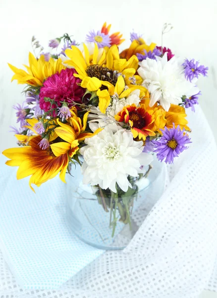Bouquet of wild flowers in glass vase on light background — Stock Photo, Image