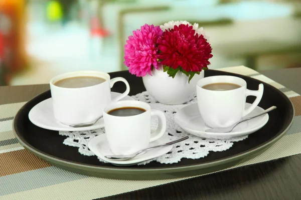 Cups of coffee on tray on table in cafe — Stock Photo, Image