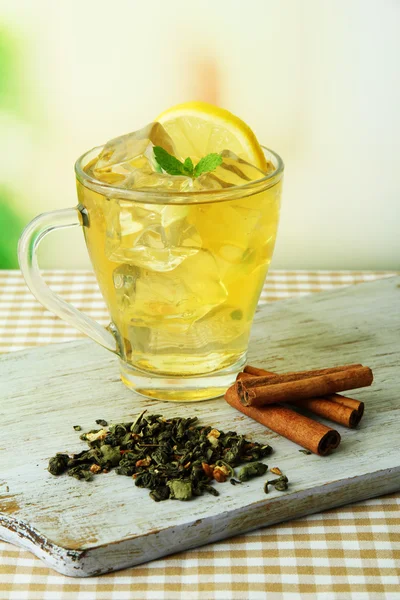 Transparent cup of ice green tea on table on bright background — Stock Photo, Image