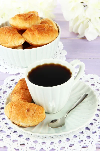 Croissants savoureux et tasse de café sur la table close-up — Photo