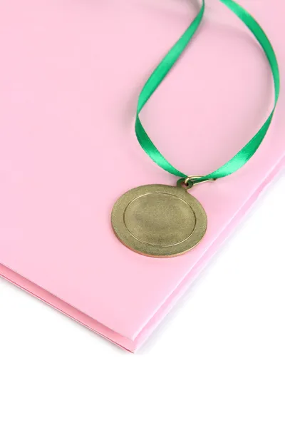 Medal for achievement in education and notebook close up — Stock Photo, Image