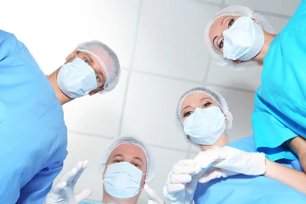 Vista desde abajo de los cirujanos en desgaste protector del trabajo durante la operación — Foto de Stock