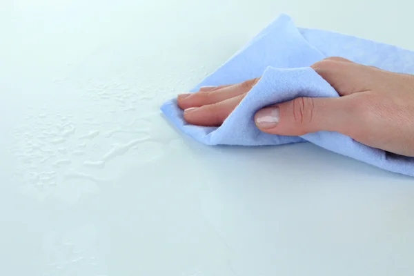 Hand wiping surface with blue rag isolated on white — Stock Photo, Image