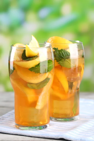 Iced tea with lemon and mint on wooden table, outdoors — Stock Photo, Image