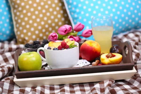 Овсянка в тарелке с ягодами на салфетках на деревянном подносе на плохом — стоковое фото