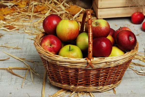 Pommes dans le panier avec paille sur fond en bois — Photo