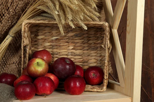 Ripe apples in basket on shelf close up — Stock Photo, Image