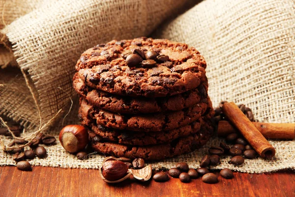 Homemade cookies with sesame seeds, chocolate, on wooden table, on sackcloth background — Stock Photo, Image