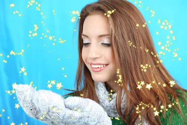 Krásná usměvavá dívka s sněhu na modrém pozadí — Stock fotografie