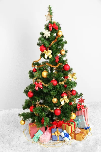 Árvore de Natal decorada com presentes no fundo da parede cinza — Fotografia de Stock