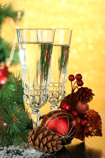 Composition with Christmas decorations and two champagne glasses, on bright background — Stock Photo, Image