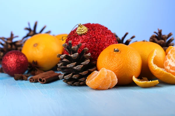 Composición navideña con mandarinas sobre mesa de madera sobre fondo azul —  Fotos de Stock