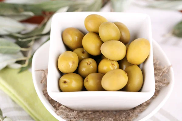 Olives in bowl with branch on napkin close-up — Stock Photo, Image