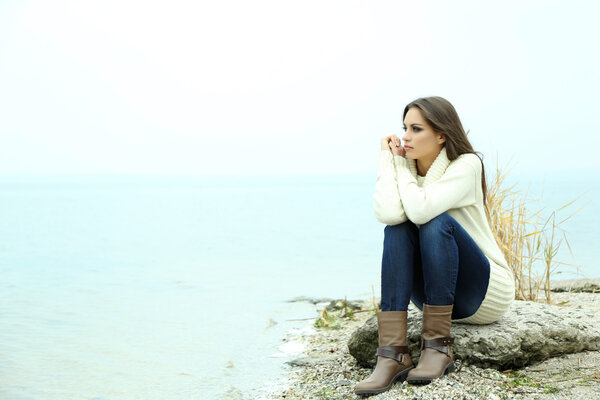 Portrait of young serious woman near river