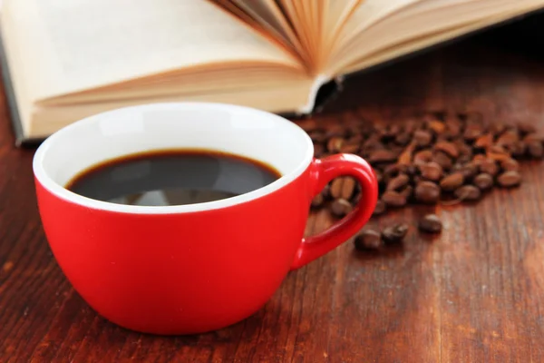 Kopp kaffe med kaffebönor och bok om trä bakgrund — Stockfoto