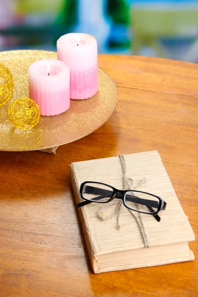 Composizione con vecchio libro, occhiali da vista, candele, fiori su sfondo luminoso — Foto Stock