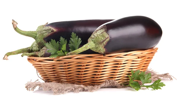 Verse aubergines in rieten mand geïsoleerd op wit — Stockfoto