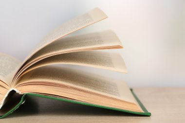 parlak zemin üzerine ahşap masa kitap açıldı