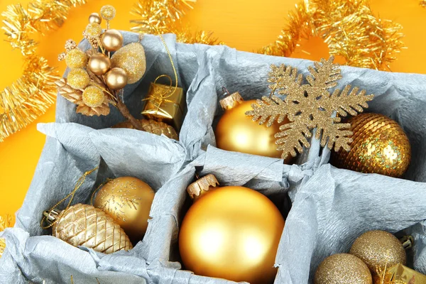 Christmas toys in wooden box on yellow background — Stock Photo, Image