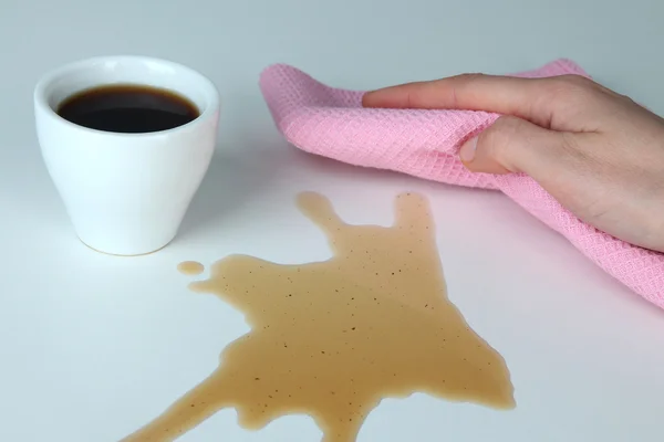 Hand wiping surface with pink rag and cup of coffee isolated on white — Stock Photo, Image