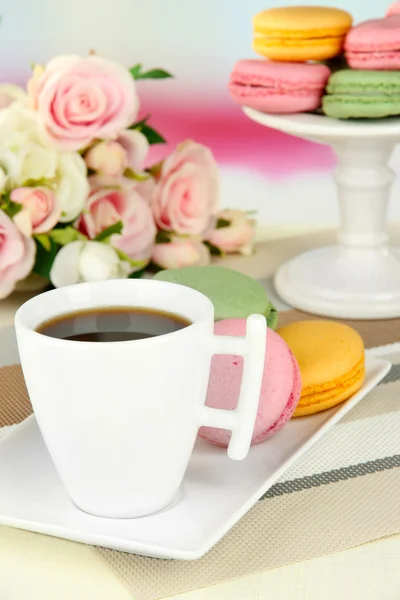 Kaffee und Makronen auf dem Tisch vor hellem Hintergrund — Stockfoto