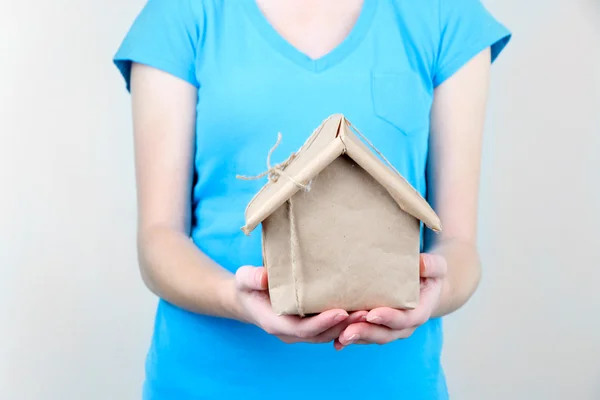 Domu trzymając się za ręce kobiety owinięte w papier pakowy brązowy — Zdjęcie stockowe
