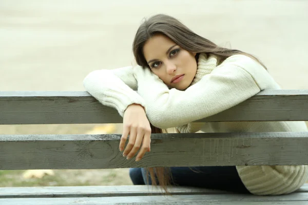 Jovem mulher solitária no banco no parque — Fotografia de Stock