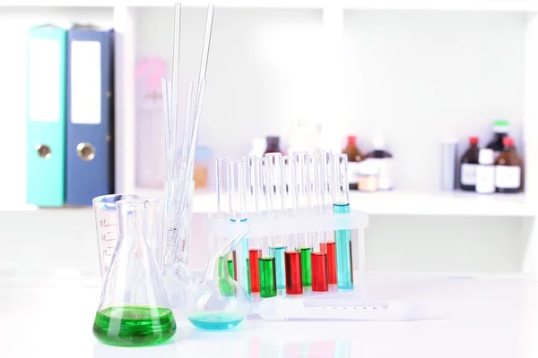 Different laboratory glassware with color liquid on laboratory background — Stock Photo, Image