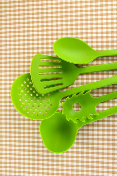 Plastic kitchen utensils on fabric background — Stock Photo, Image