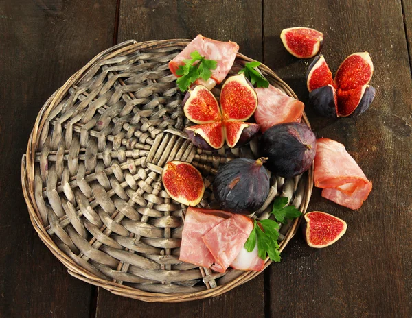 Figues savoureuses avec jambon sur table en bois gris — Photo