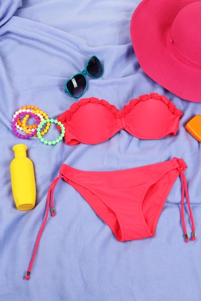 Zwembroek en strand items op paarse achtergrond — Stockfoto