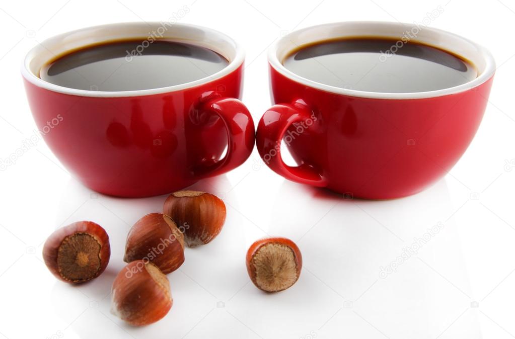 Red cups of strong coffee and nuts isolated on white
