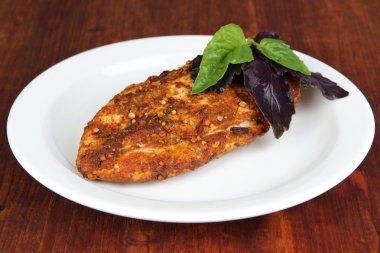 ahşap zemin üzerinde beyaz tabakta tavuk fileto kavrulmuş