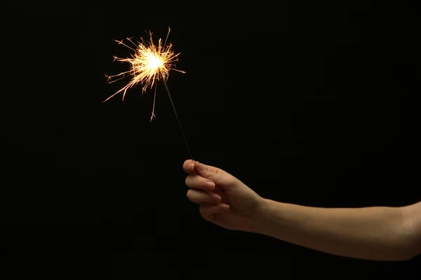 Belo sparkler na mão mulher no backgroun preto — Fotografia de Stock