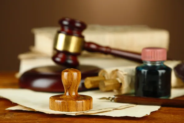 Wooden stamp, gavel and old papers on wooden table — Stock Photo, Image