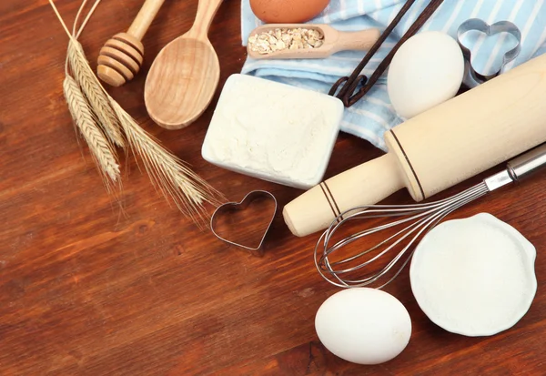 Conceito de cozinha. Ingredientes básicos de cozimento e utensílios de cozinha na mesa de madeira — Fotografia de Stock